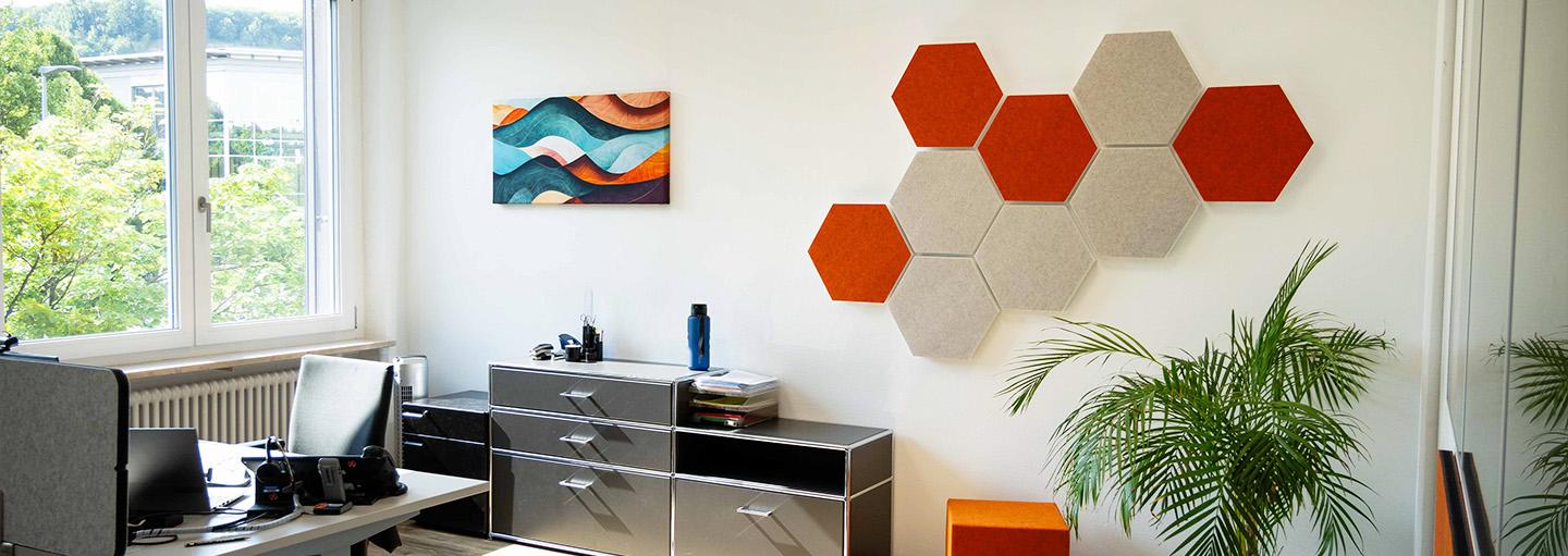 Anwendung Schallabsorber Sechseckige Schallabsorber in orange und Greige an einer Wand