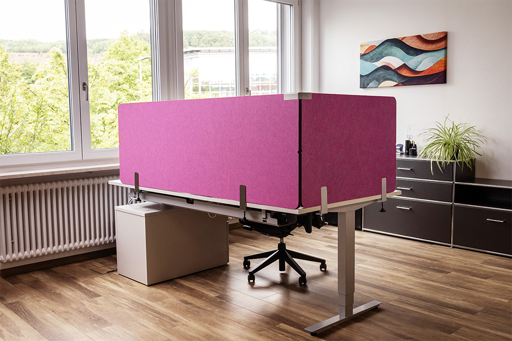 Pinke Tischtrennwand in einem Büro auf dem Schreibtisch montiert