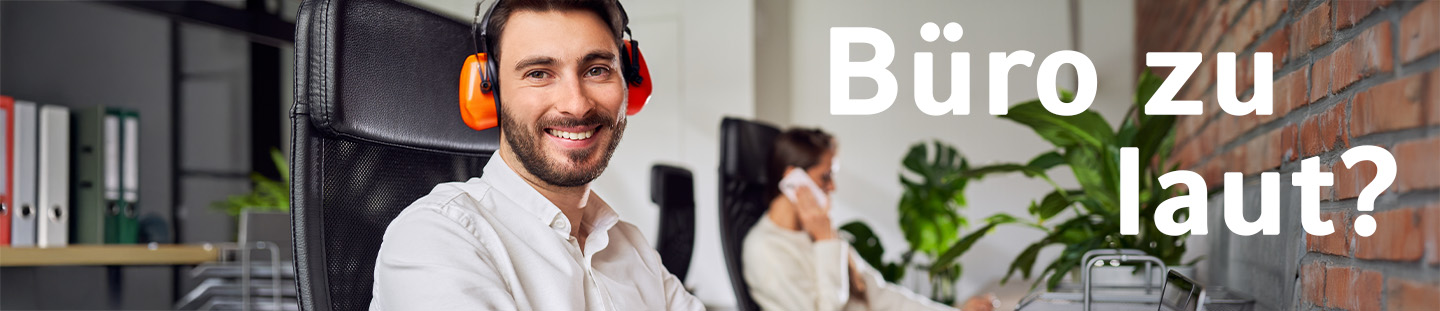Büro zu laut? Mann mit Gehörschutz sitzt am Schreibtisch
