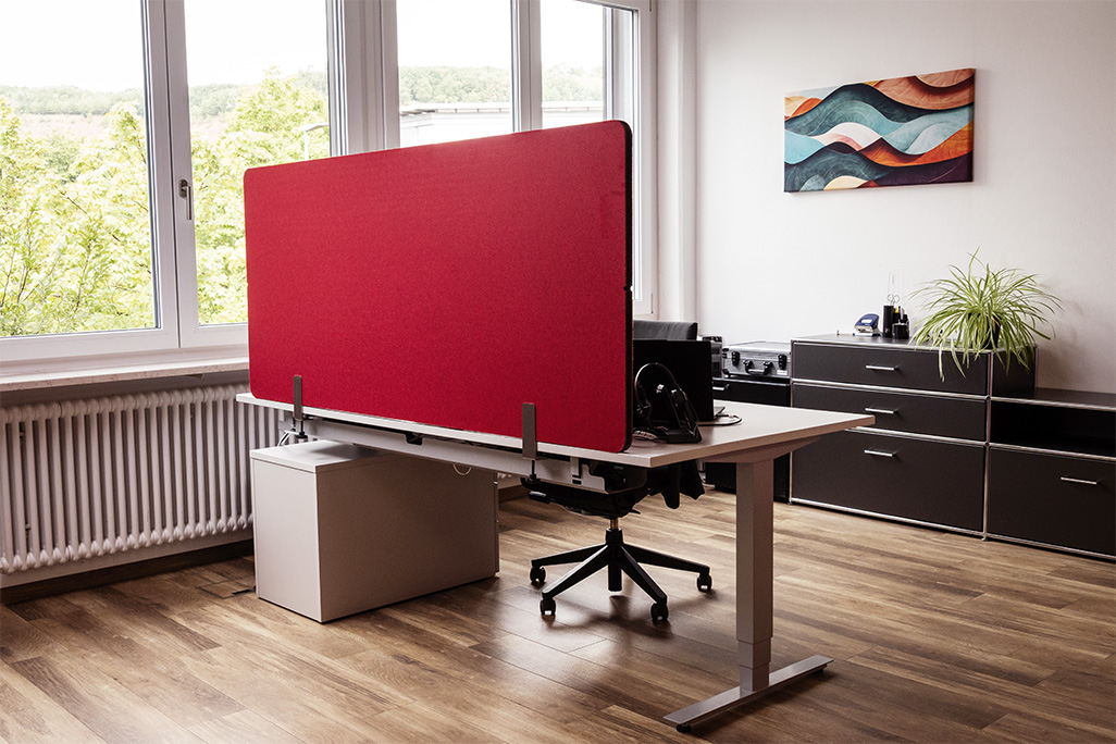 Rote Tischtrennwand in einem Büro auf dem Schreibtisch montiert