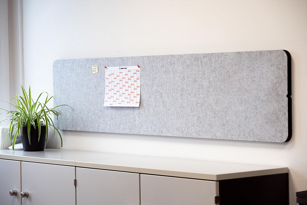 soni Tischtrennwand Light gray table partition attached to a wall above a sideboard, which is used as a pinboard.