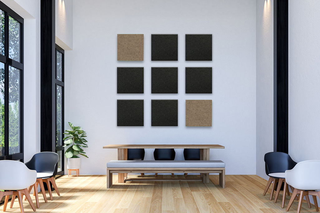 Bright café with white walls, a high ceiling, black and grey furniture, complemented by square, colored acoustic elements on the wall.